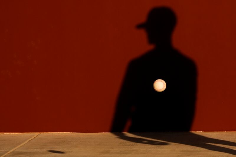 A Seattle Mariners baseball player tosses a ball against a wall during drills at spring training, in Peoria, Arizona.  AP