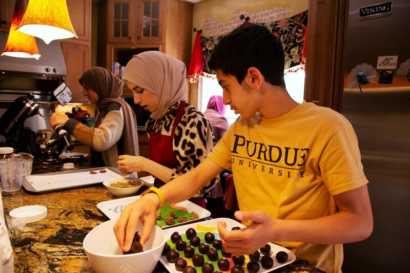 Fatema Zuhayli and her children Ayah, Patul and Yunis Kutmah make sweets the day before Eid at their home in Louisville, Kentucky, U.S. Reuters