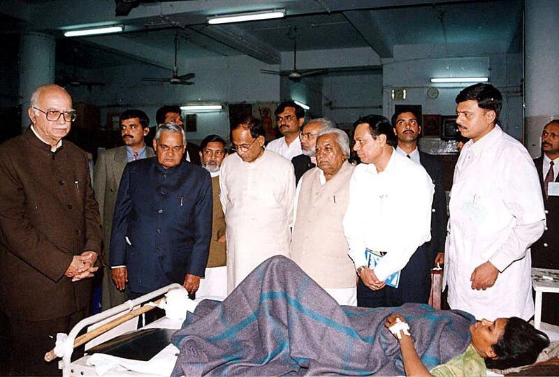 Indian home minister L.K.Advani (L) and Prime Minister Atal Behari Vajpayee (2nd/L) visit an injured earthquake victim at an army hospital in Bhuj, 29 January 2001. More than 20,000 people are feared dead in the worst disaster to hit India for five decades. AFP PHOTO STR (Photo by STR / AFP)