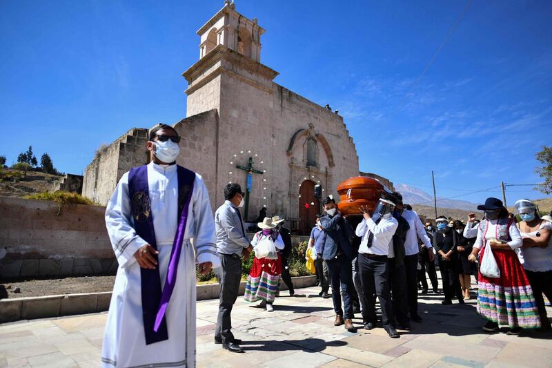 Residents of the rural community of Yura, close to the city of Arequipa in southern Peru, participate in the burial of their mayor Angel Benavente, who died after contracting Covid-19, with an outdoor mass and an animated funeral possession. AFP