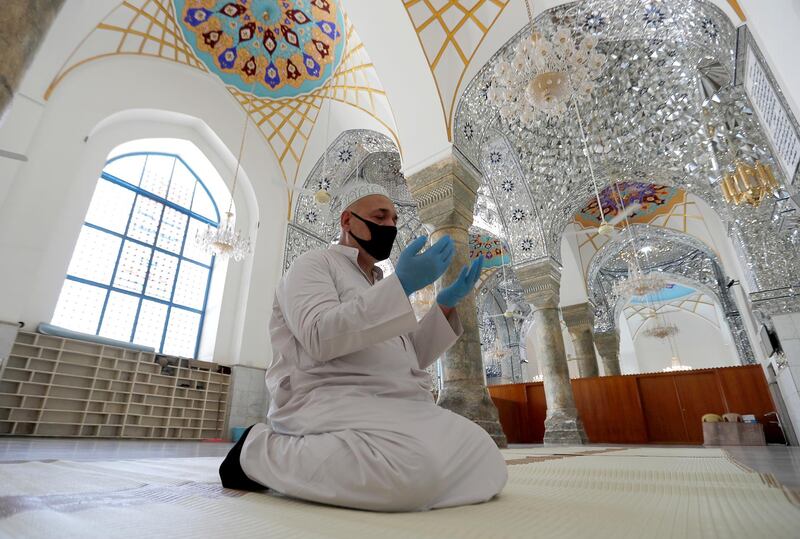 A muezzin of the shrine of Sheikh Abdul Qadir Jeelani prays alone since all places of worship remain closed as part of the preventive measures against the spread of the coronavirus disease (COVID-19) during the holy fasting month of Ramadan in Baghdad, Iraq May 13, 2020. REUTERS/Thaier al-Sudani