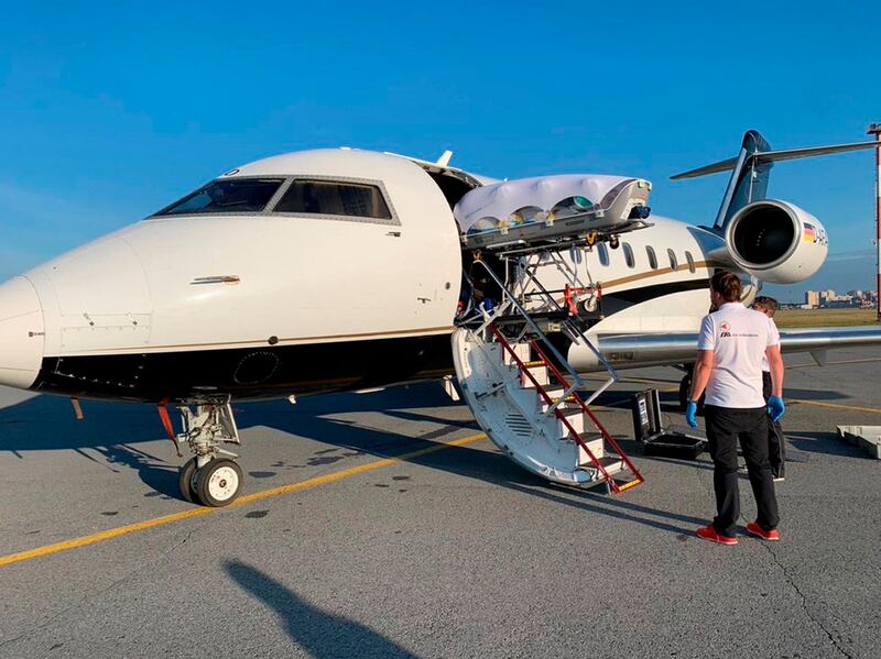 Medics upload Alexei Navalny into a German special medical plane at an airport in Omsk. Alexei Navalny's press team via AP