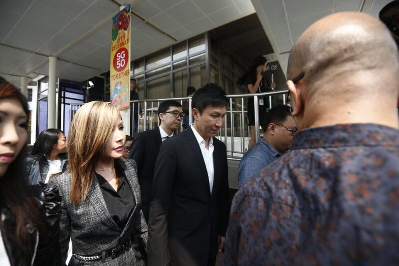 City Harvest Church pastor Kong Hee, centre, and his wife Ho Yeow Sun, left, outside the state court in Singapore, 21 October 2015. The founder of City Harvest Church, Kong Hee has been found guilty of embezzling church funds, along with five other leaders of the church. Wallace Woon/EPA