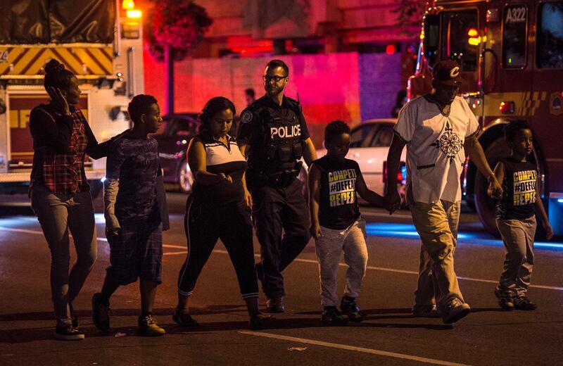 Police escort civilians away from the scene of a shooting in Toronto. AP Photo