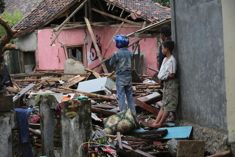 A man inspects his damanged house in Sumur. AP Photo