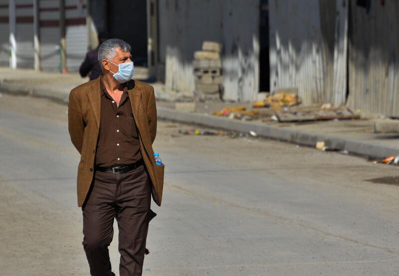 An Iraqi man wearing a protective mask walks in a deserted street in the northern Iraqi city of Mosul. AFP