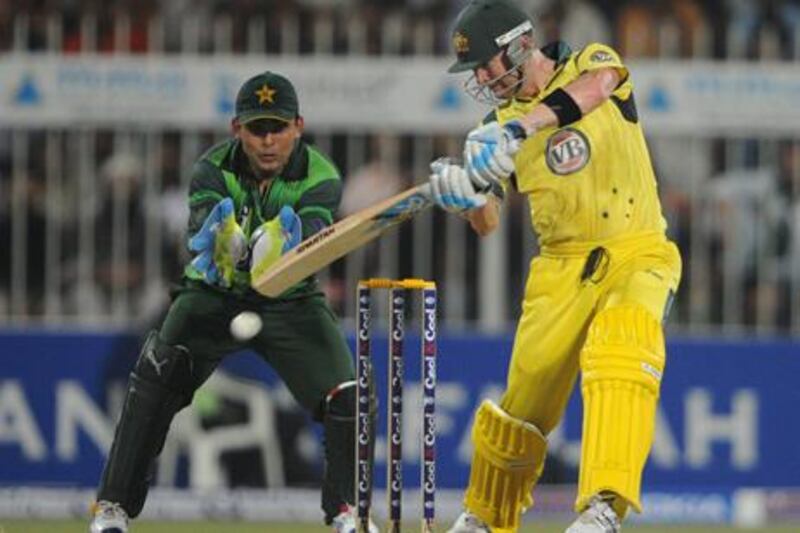 Australia captain Michael Clarke plays a shot as Kamran Akmal looks on for Pakistan