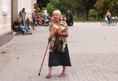 A woman holds bread after attending a distribution of humanitarian aid in Bakhmut, Ukraine. Reuters