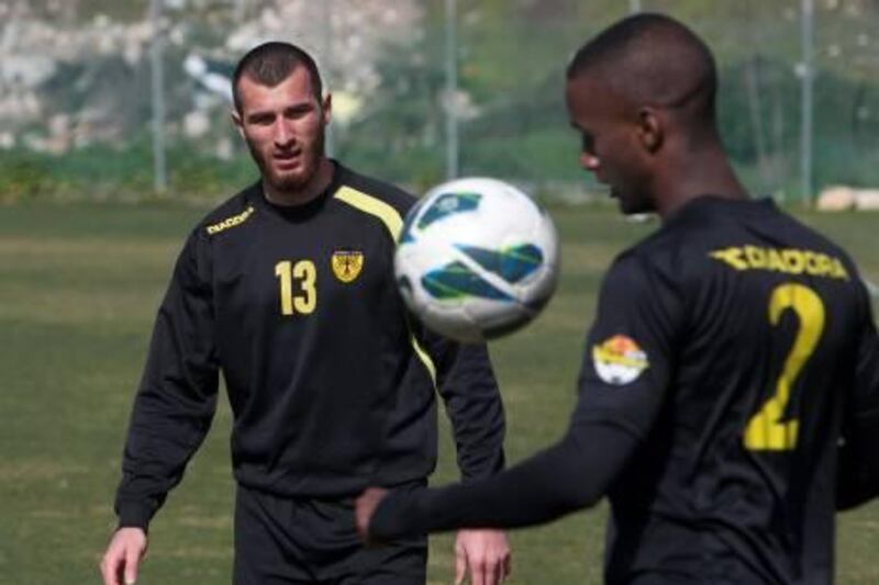 Zaur Sadayev (L), a Chechen Muslim player who was recruited by Israeli Premier League side Beitar Jerusalem, practices during a training session in Jerusalem February 8, 2013. A suspected arson attack damaged the main club house of Beitar Jerusalem on Friday, a day after four fans were charged in court in connection with racist incitement against the team's recruitment of Muslim players, one of them Sadayev, police said. REUTERS/Ronen Zvulun (JERUSALEM - Tags: CRIME LAW SPORT SOCCER) *** Local Caption ***  JER5_SOCCER-ISRAEL-_0208_11.JPG