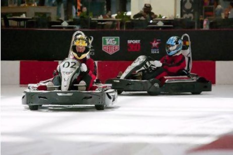 Neil Vorano (number 02) aligns his kart after a curve to power down the (very) short straight at the Dubai Ice Rink last weekend. Duncan Chard for The National