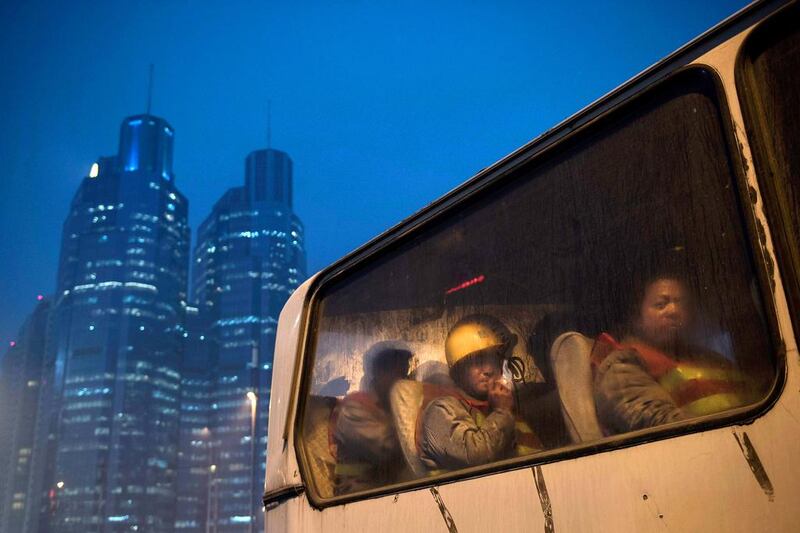 Chinese migrant workers wait in a bus as they leave after their shift at a construction site on December 9, 2014 in Beijing, China. It is estimated that there are more than 40 million construction labourers in China, many of whom come from smaller centers to the country's larger cities to find work. Kevin Frayer / Getty Images