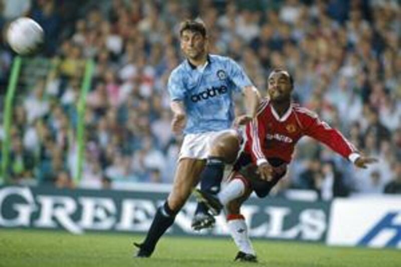 Manchester United's Danny Wallace, right, crosses the ball as he is challenged by Manchester City's David White during a 1989 derby. City won the game 5-1 at Maine Road, one of their most famous victories.