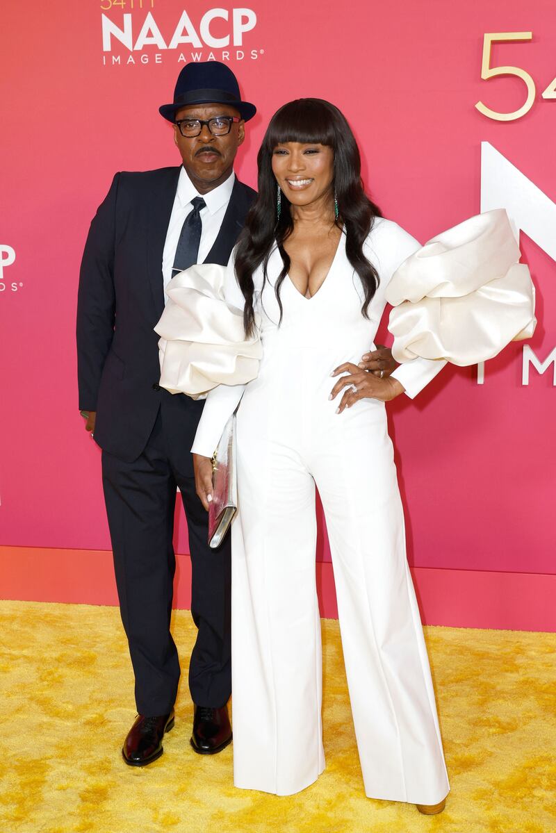 Angela Bassett in a jumpsuit with statement sleeves by Laura Basci, with husband Courtney B Vance. AFP