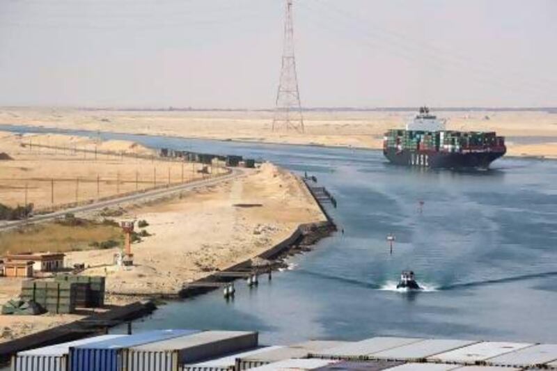 A Suez Canal Authority pilot vessel navigates a convoy of container ships as they pass southbound on the canal. Kristian Helgesen / Bloomberg News