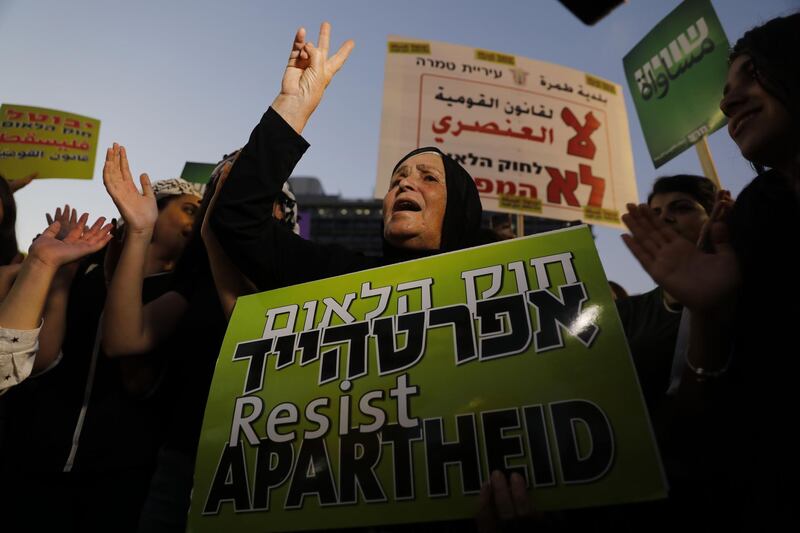 A woman shouts slogans as Arab Israelis and their supporters demonstrate during a rally to protest against the 'Jewish Nation-State Law' in the Israeli coastal city of Tel Aviv on August 11, 2018. - The controversial law passed last month declaring the country the nation state of the Jewish people. This has led to concerns that Arab Israelis, who account for some 17.5 percent of Israel's more than eight million population, could now be openly discriminated against in everything from housing to budgeting and land allocation. (Photo by Ahmad GHARABLI / AFP)