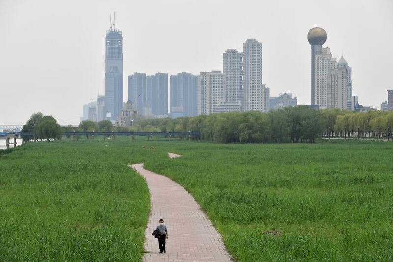 A man walks at a riverside park in Wuhan on March 26, 2020. Reuters