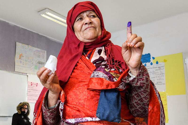 A voter shows her ink-stained finger after voting at a polling station during the 2023 local elections in Ariana province. AFP