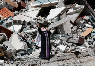 A woman reacts while standing near the rubble of a building that was destroyed by an Israeli airstrike on Saturday that housed The Associated Press, broadcaster Al-Jazeera and other media outlets, in Gaza City, Sunday, May 16, 2021. (AP Photo/Adel Hana)