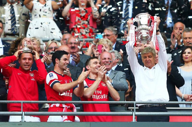 Arsenal manager Arsene Wenger, right, finally gets to lift a trophy in celebration. Clive Mason / Getty Images


