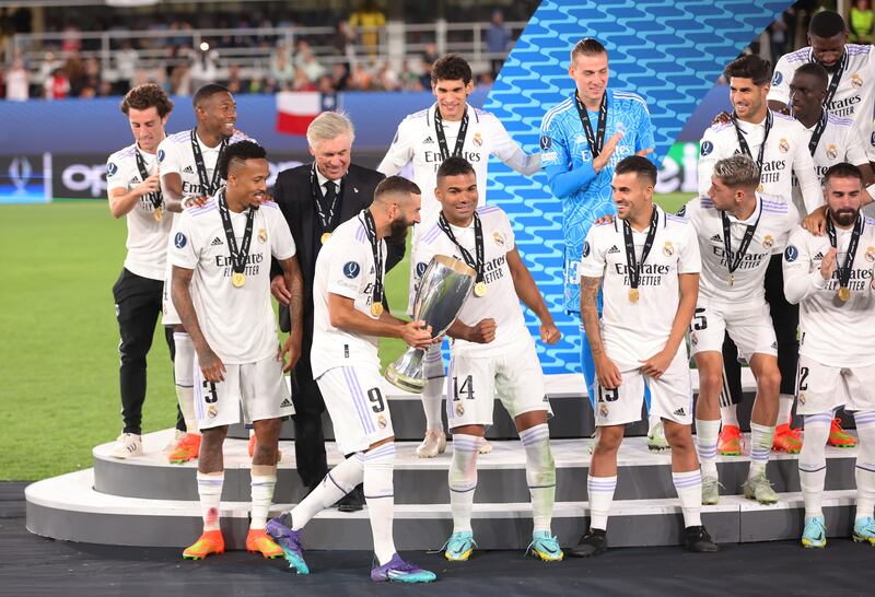 Players of Real Madrid look on as Karim Benzema walks the Uefa Super Cup trophy onto the stage during the trophy presentation. Getty Images