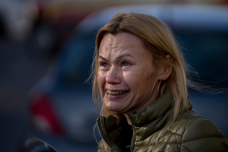 A woman outside her apartment building after it was damaged by a rocket, in Kiev. AP