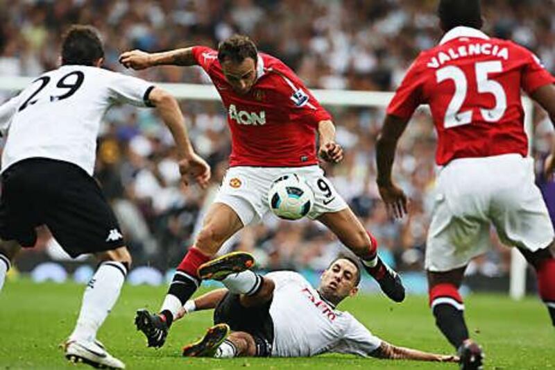 Dimitar Berbatov, centre, the Manchester United striker, is tackled by Fulham's Clint Dempsey as the two sides fought out a 2-2 draw at Craven Cottage.