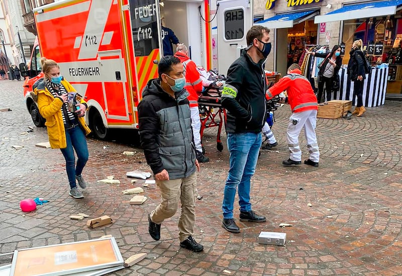 Police look on as rescuers push an injured person into an ambulance at the scene. AFP