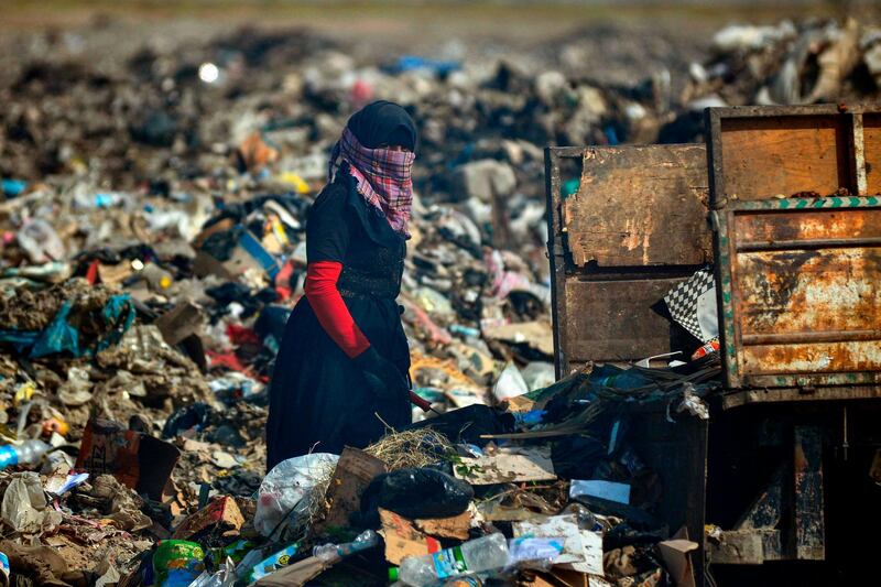 An Iraqi woman looks on while rummaging through trash at a landfill in Diwaniyah, around 160km south of the capital Baghdad. AFP
