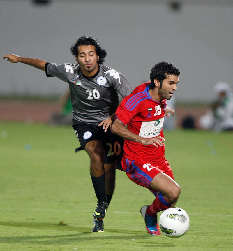 Al Ain, United Arab Emirates, Sept. 14 2012, Al Dhafra v Al Shaab- (red kit) Al Shaab's #25 (no player list) gets fouled in  first half action by Al Dhafra's #20 (blk and green kit) . Sept. 14, 2012 at Khalifa Bin Zayed Stadium. Mike Young / The National