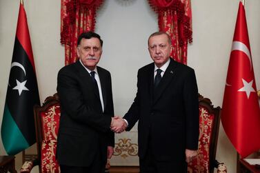 A February 2020 photo shows Turkey President Recep Tayyip Erdogan shaking hands with the head of Libya's Government of National Accord (GNA) Fayez al-Sarraj during their meeting at Dolmabahce palace in Istanbul. AFP PHOTO / Murat Cetimmuhurdar / Turkish Presidential Press Service