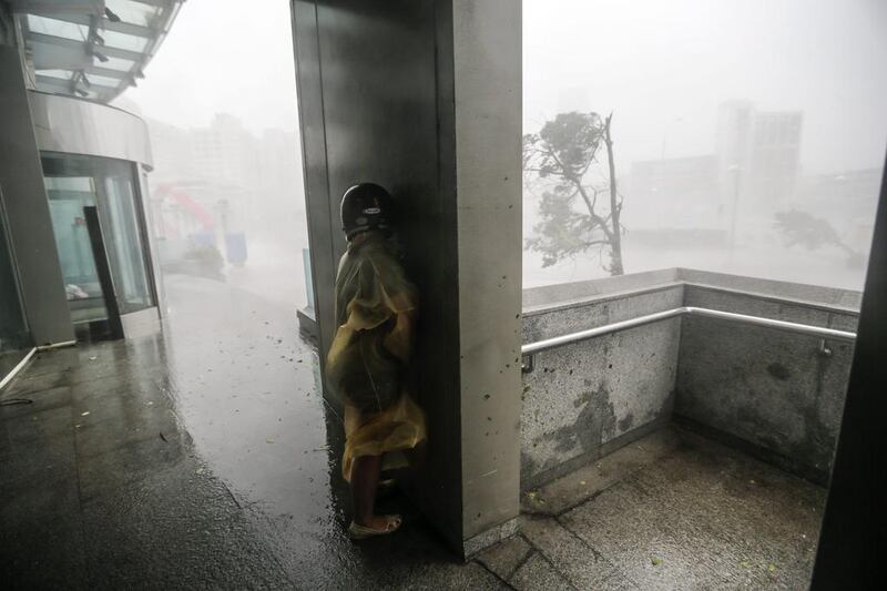 A motorist takes cover on a wall as winds and rain from Super Typhoon Meranti lash Kaohsiung, southern Taiwan. The storm is the strongest recorded since Super Typhoon Haiyan developed in 2013. EPA