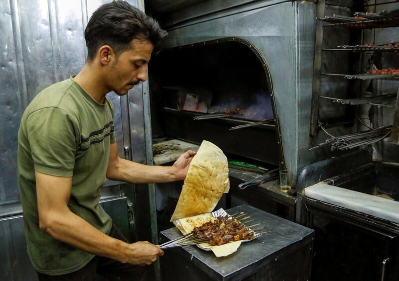 An employee grills meat at a restaurant in Damascus, Syria. Reuters