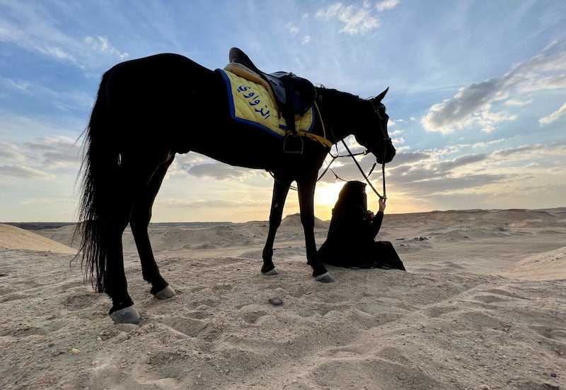 Egyptian trainer Basant Allam watches the sunset with her horse while sitting on Mount Sakkara in Giza, Egypt. Reuters