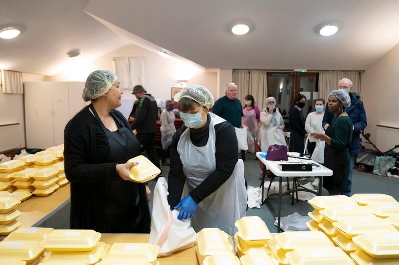 Glenda Andrew talks to volunteer Diane Proctor as members of the Preston Windrush Covid Response team dish out West Indian meals at the Xaverian Sanctuary in Preston. AP Photo