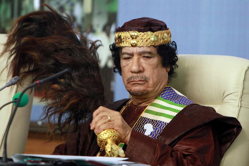 FILE - In this Sept. 8 2010 file photo, Libyan leader Moammar Gadhafi fans his face during the Forum of Kings, Princes, Sultans, Sheikhs and Mayors of Africa in Tripoli. President Trump and his hawkish national security adviser have both referenced the Libya model ahead of the much-vaunted summit with North Koreaâ€™s Kim Jun Un, but what is the context?(AP Photo/Abdel Magid Al Fergany, file)