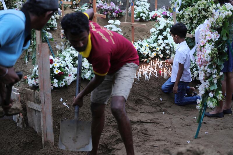 A boy lights a candle after the funeral service of Dhami Brandy, 13, who was killed during Easter Sunday's bomb blast at St. Sebastian Church, in Negombo, Sri Lanka Thursday, April 25, 2019. The U.S. Embassy in Sri Lanka warned Thursday that places of worship could be targeted for militant attacks over the coming weekend, as police searched for more suspects in the Islamic State-claimed Easter suicide bombings that killed over 350 people. (AP Photo/Manish Swarup)