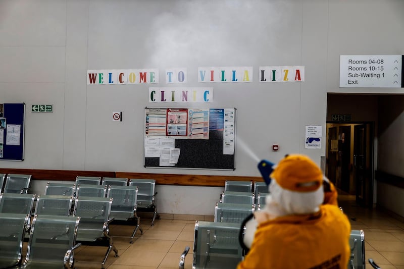 A volunteer sprays disinfectant during a deep cleaning operation inside the Villa Liza Clinic, in Ekurhuleni, South Africa. AFP