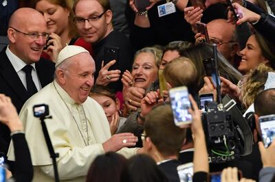 The faithful greet and take photos of Pope Francis (L) as he arrives for the weekly general audience at Paul-VI hall on January 30, 2019 at the Vatican. / AFP / Andreas SOLARO
