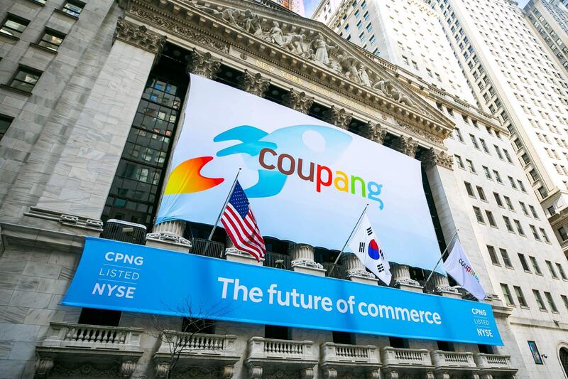 In this photo provided by the New York Stock Exchange, a banner for South Korea's Coupang adorns the New York Stock Exchange facade before his company's IPO, Thursday March 11, 2021.The biggest IPO in years is rolling out Thursday on the NYSE where Coupang, the South Korean equivalent of Amazon in the U.S., or Alibaba in China, will begin trading under the ticker "CPNG." (Courtney Crow/New York Stock Exchange via AP)