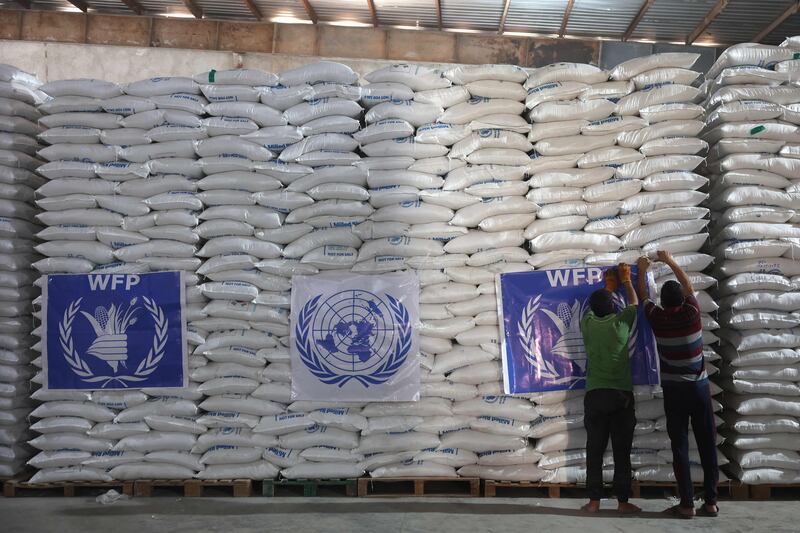 Workers unload bags of aid at a warehouse near the Syrian Bab Al Hawa border crossing with Turkey. AFP