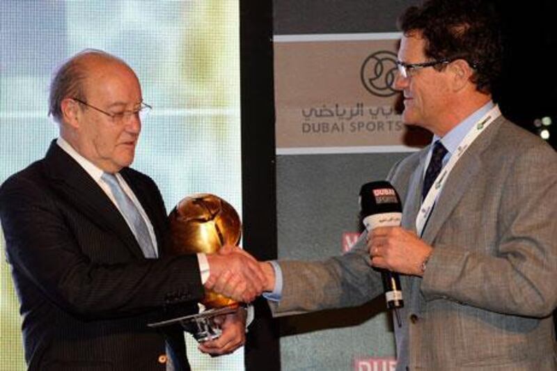 Aside from his critical comments about big-spending clubs 'stealing' youth players from small clubs, Fabio Capello, right, also took the time to present Pinto da Costa, president of Porto, with a career achievement trophy.