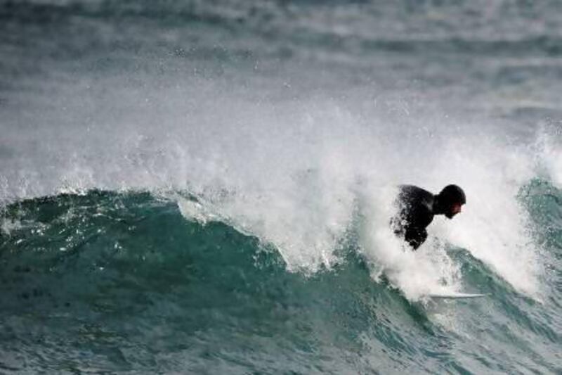 Surfing teacher Mike Dobos glides on a wave in the northern Spanish Basque village of Mundaka.