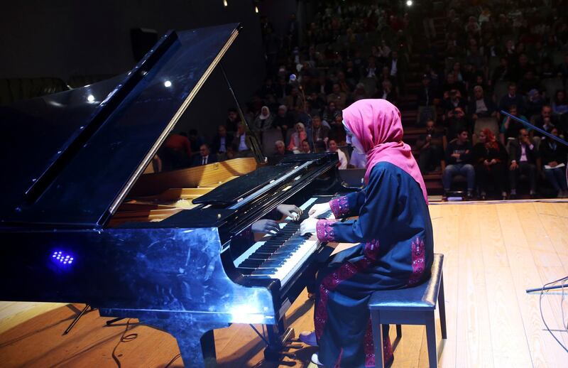 Palestinian pianist Yara Thabit plays the piano during a concert to mark the debut of Gaza's only grand piano after it was rescued from conflict, at a theater nestled in the Palestinian Red Crescent Society's building in Gaza City, Sunday, Nov. 25, 2018. The only grand piano in the Gaza Strip is debuting to the public for the first time in over a decade after its restoration. (AP Photo/Adel Hana)