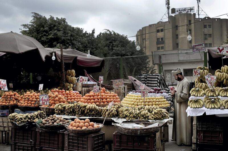 In this Tuesday, Feb. 14, 2017 photo, a fruit vendor checks an apple as he waits for customers in the Sayeda Zeinab neighborhood of Cairo, Egypt. Egyptians are cutting spending and trying to make it through the country‚Äôs worst inflation in a decade under President Abdel-Fattah el-Sissi‚Äôs economic reforms. With inflation now nearing 30 percent _ and little public space for discontent _ they‚Äôre finding they can do little else but bear down and hope the promised benefits of reform eventually come. (AP Photo/Nariman El-Mofty)