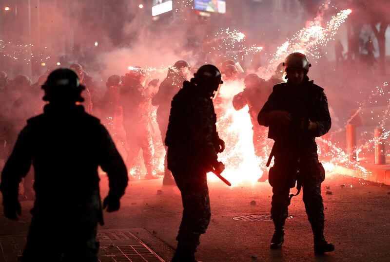 Lebanese riot policemen react to firecrackers that were fired by the supporters of the Shiite Hezbollah and Amal Movement groups. AP