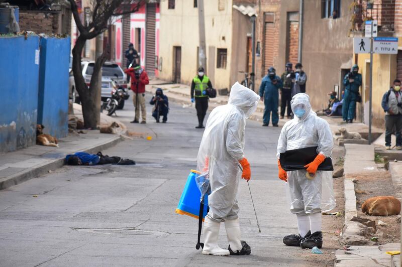 State department health workers arrive to recover the  body of a street vendor who was found at dawn by his neighbours in the Cerro San Miguel neighbourhood of Cochabamba, Bolivia. AP