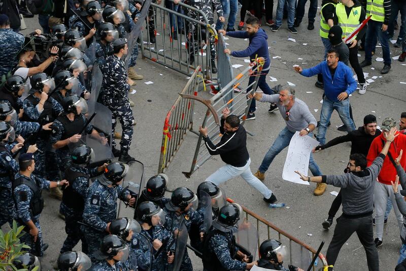 Lebanese anti-government protesters clash with riot policemen as they try to reach the government building in central Beirut, Lebanon, Sunday, Dec. 23, 2018. Hundreds of Lebanese protested against deteriorating economic conditions as politicians are deadlocked over forming a new government. (AP Photo/Bilal Hussein)