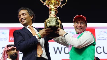 Trainer Bhupat Seemar, left, and Tadhg O'Shea celebrate with the trophy after winning the Dubai World Cup. Reuters