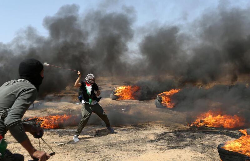 A demonstrator uses a sling to hurl stones at Israeli forces.  Ibraheem Abu Mustafa / Reuters