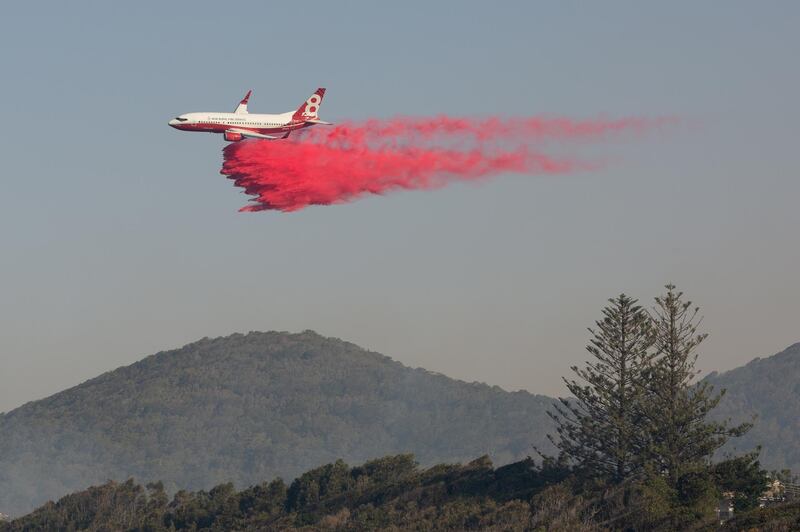A water bomber aircraft drops fire retardant on a bushfire in Forster, New South Wales. EPA